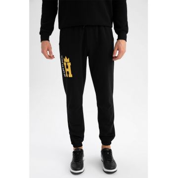 Pantaloni sport cu croiala conica si buzunare laterale