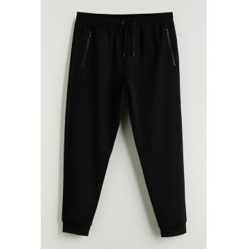 Pantaloni conici de trening cu buzunare cu fermoar