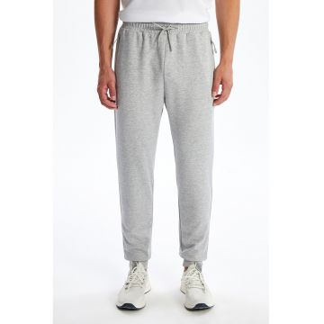 Pantaloni de trening cu croiala conica si buzunare cu fermoar